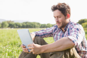 Mann erledigt landwirtschaftliche Buchführung am Tablet